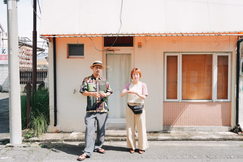 ニューシマヤの外観前に並んで立つ西澤康介さんと日菜子さん